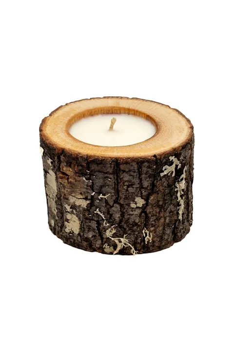 A natural scented candle in an oak wooden vessel with dark bark, custom-made for a furniture shop