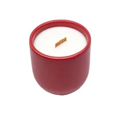 A natural scented candle in a cardinal red matt ceramic vessel, custom-made for the product line of a European brand